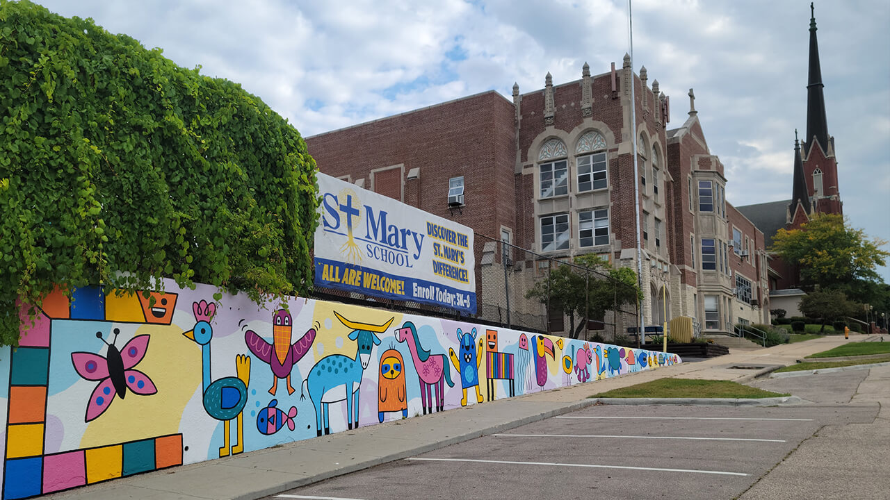 An exterior wall of our playground features a wonderfully happy mural by muralist Emily Balsley
